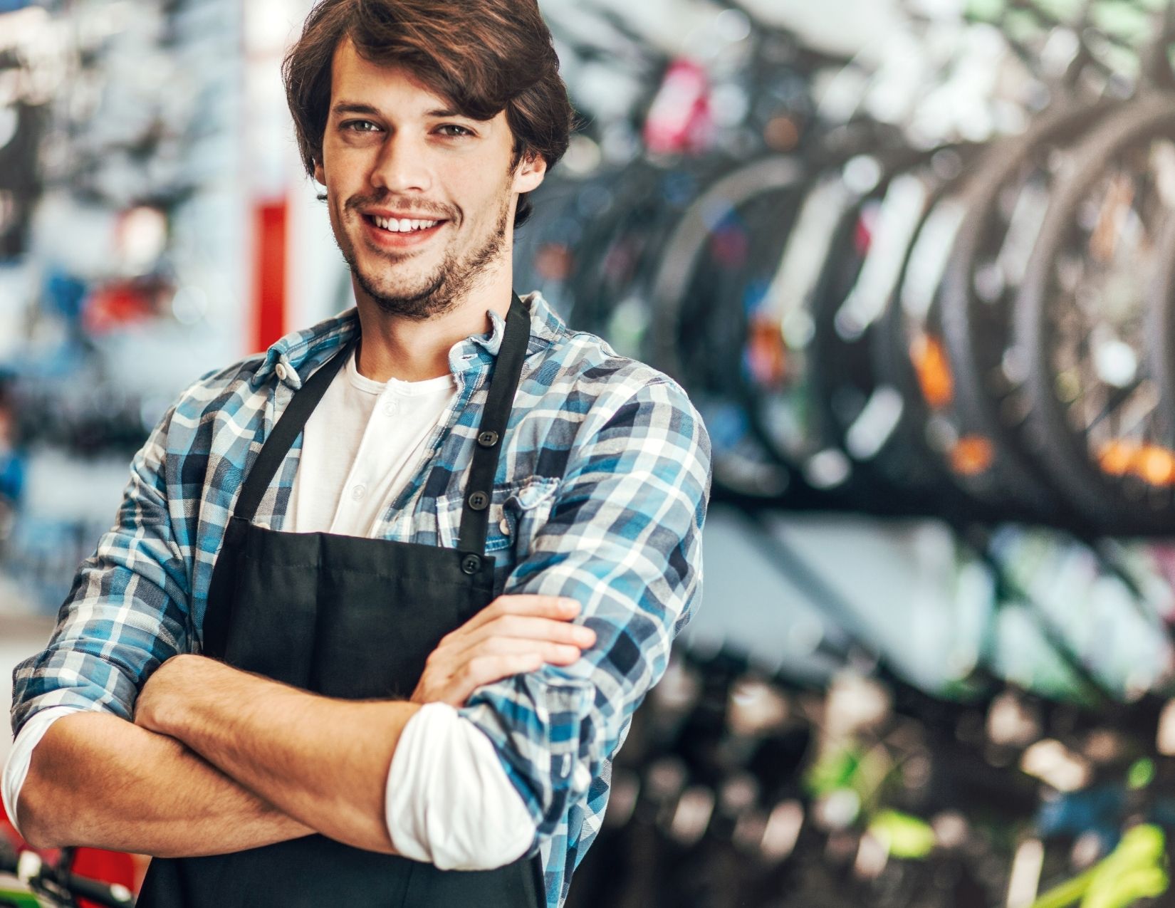 Young man with invisible disability standing behind counter in bicycle store